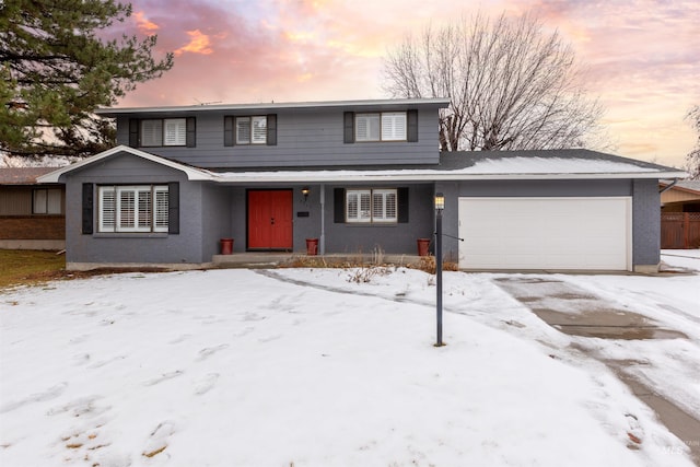 traditional-style house featuring an attached garage and brick siding