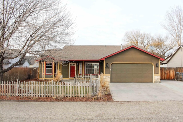 single story home featuring a garage, a fenced front yard, driveway, and stone siding