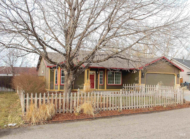 ranch-style house featuring an attached garage and a fenced front yard