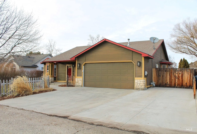 view of front facade featuring an attached garage, stone siding, driveway, and fence