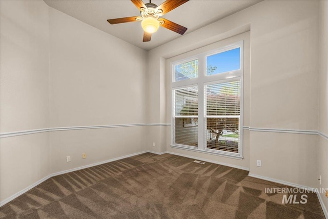 empty room featuring carpet, baseboards, and ceiling fan