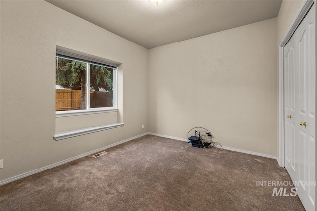 spare room with carpet and baseboards