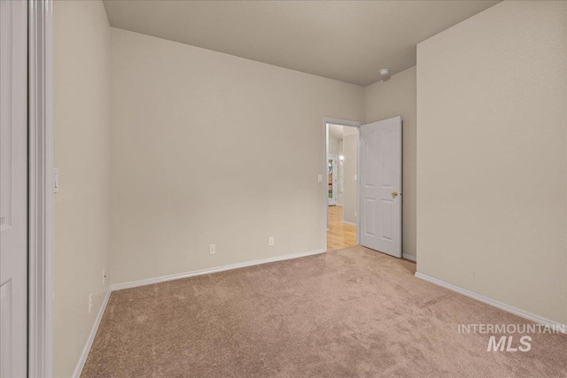 unfurnished room featuring carpet and baseboards