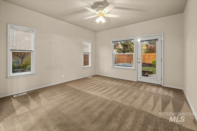 spare room featuring carpet floors, baseboards, and ceiling fan