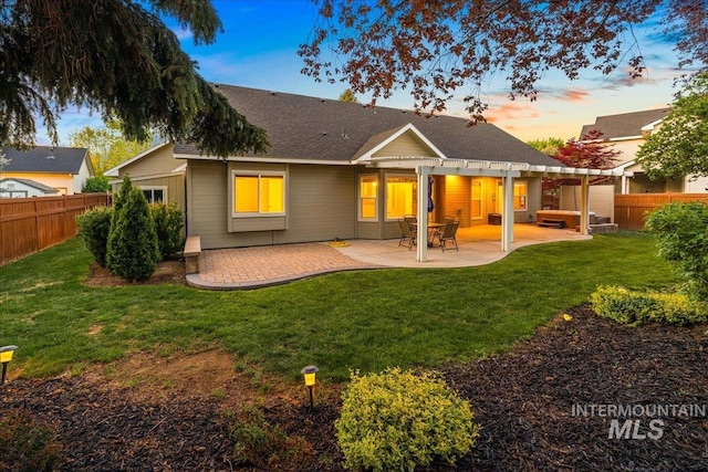 back of house at dusk with a pergola, a patio, and roof with shingles