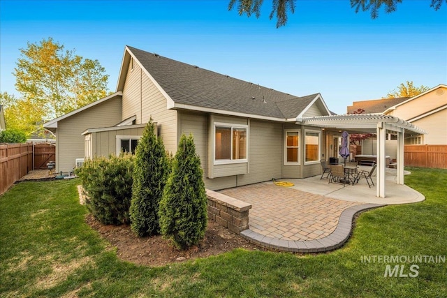back of property with a pergola, a patio area, and a shingled roof