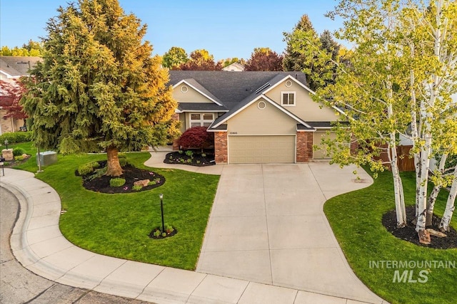 view of front of home with driveway, a front lawn, brick siding, and a garage