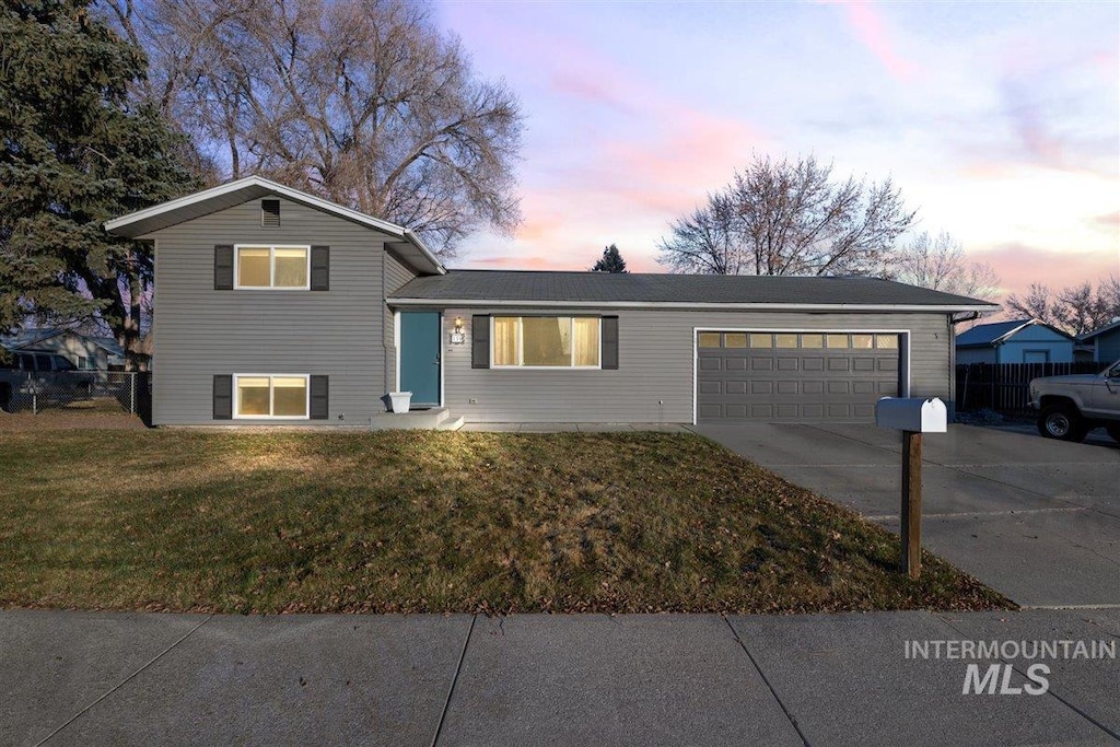 tri-level home featuring a lawn and a garage