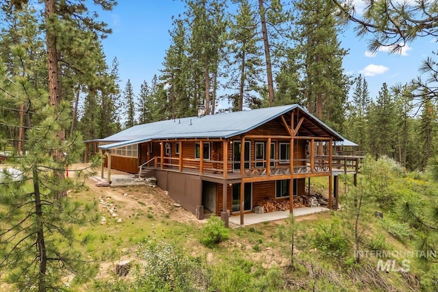 9 Elderberry Cir, Idaho City, ID 83631 - back of property with a wooden deck, a patio, a forest view, and metal roof