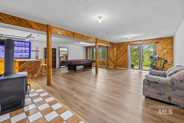 9 Elderberry Cir, Idaho City, ID 83631 - playroom featuring a wood stove, billiards, wooden walls, wood finished floors, and a textured ceiling