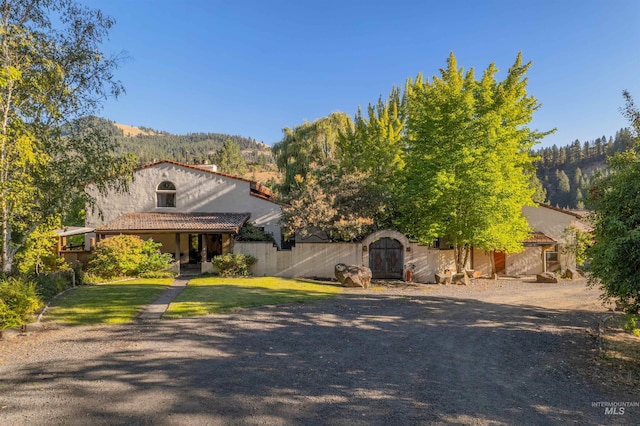 view of front of property featuring a front lawn, a shed, and a mountain view