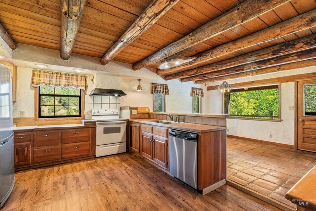 carpeted spare room with wood ceiling, baseboard heating, wooden walls, and beam ceiling