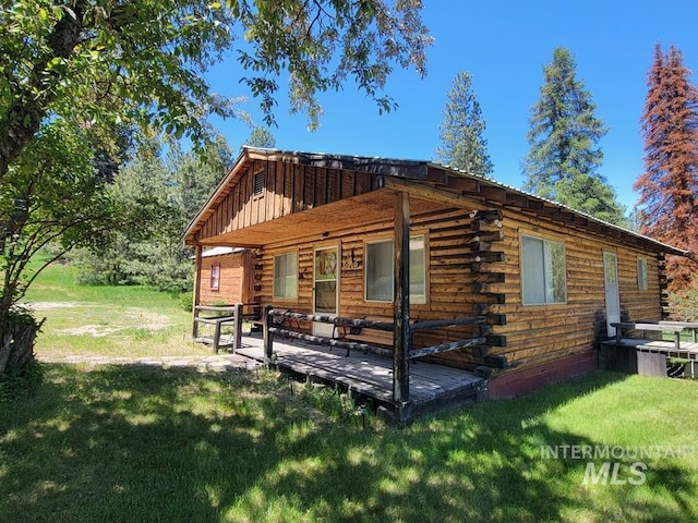 607/611 S Main St, Cascade, ID 83611 - back of property with log siding, a lawn, and a deck