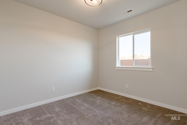 unfurnished room featuring carpet flooring, visible vents, and baseboards