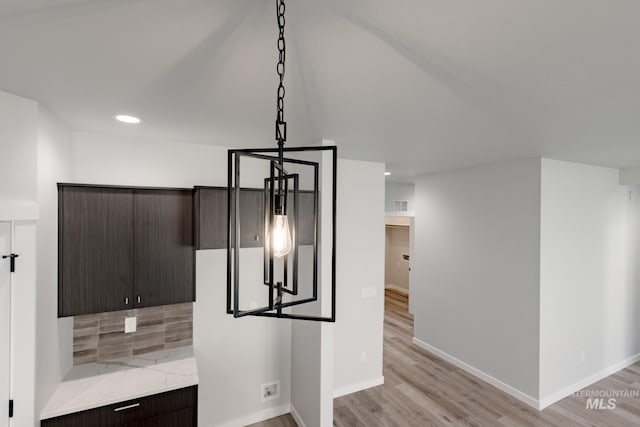 kitchen with tasteful backsplash, visible vents, baseboards, dark brown cabinets, and light wood-style floors