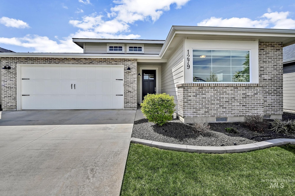 1279 W Bolton, Eagle, ID 83646 - view of front facade with brick siding, a garage, and driveway