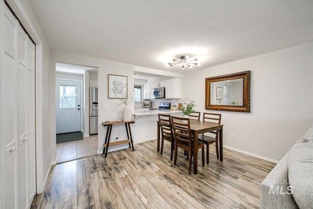 3017 S Windstream Ln, Boise, ID 83706 - dining space with light wood-style floors, healthy amount of natural light, baseboards, and a chandelier