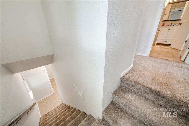 3017 S Windstream Ln, Boise, ID 83706 - stairway with tile patterned floors, a textured wall, carpet, and baseboards