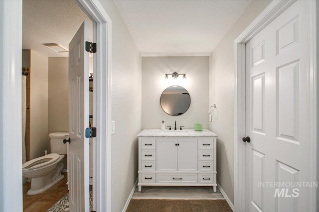 3017 S Windstream Ln, Boise, ID 83706 - bathroom featuring vanity, toilet, baseboards, a textured wall, and a textured ceiling