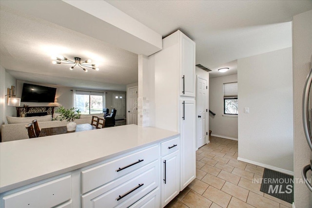 3017 S Windstream Ln, Boise, ID 83706 - kitchen with light countertops, open floor plan, baseboards, white cabinetry, and light tile patterned floors