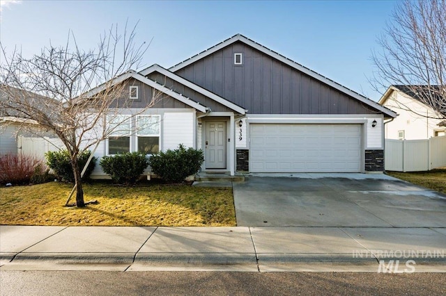 view of front of house with a garage, concrete driveway, and fence