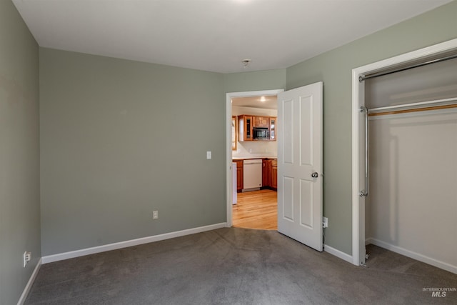 unfurnished bedroom with baseboards, a closet, and light carpet
