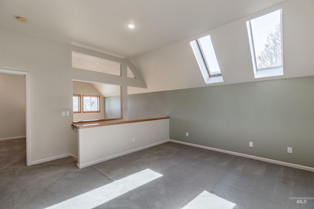 unfurnished room with recessed lighting, baseboards, carpet flooring, and lofted ceiling with skylight