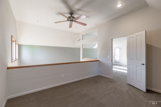 carpeted spare room with baseboards, ceiling fan, and vaulted ceiling
