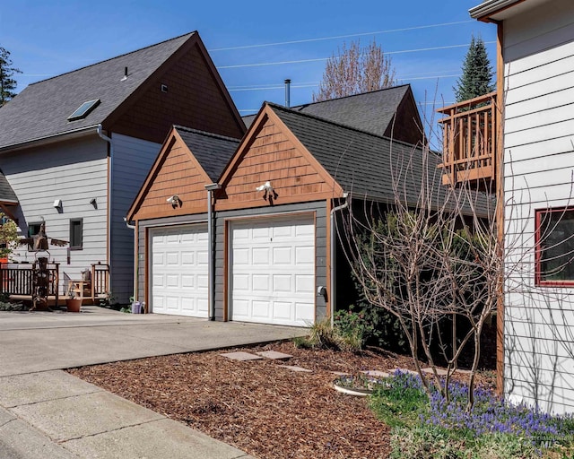 view of property exterior featuring concrete driveway and a shingled roof