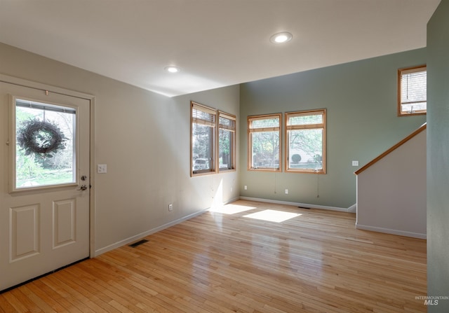 foyer with visible vents, stairs, baseboards, recessed lighting, and light wood finished floors