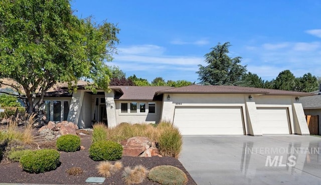 view of front of home with an attached garage, driveway, and stucco siding