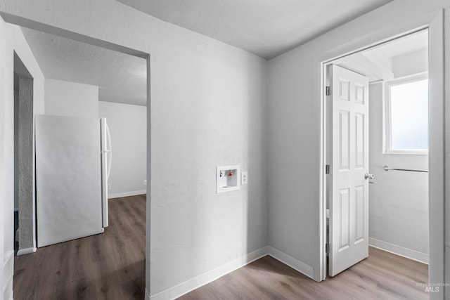 laundry area featuring hookup for a washing machine, laundry area, baseboards, and wood finished floors