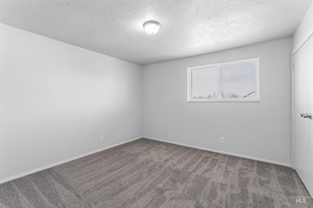 carpeted empty room featuring baseboards and a textured ceiling