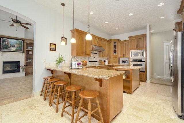 kitchen featuring stainless steel appliances, under cabinet range hood, a peninsula, ceiling fan, and recessed lighting