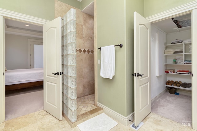 ensuite bathroom with a walk in shower and baseboards
