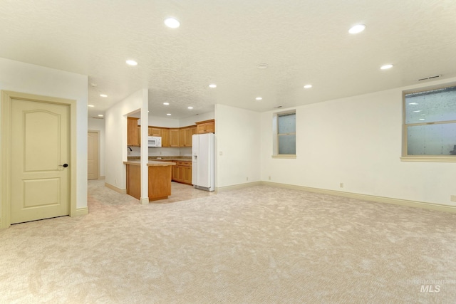 unfurnished living room featuring recessed lighting, light colored carpet, and baseboards