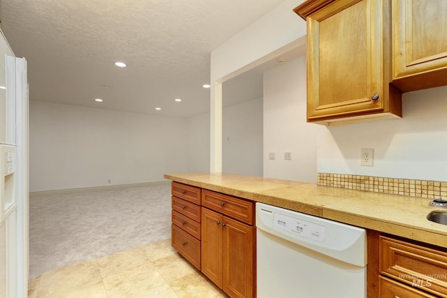kitchen with white dishwasher, recessed lighting, light colored carpet, light countertops, and brown cabinets