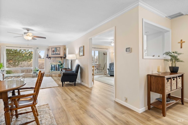 dining space featuring ornamental molding, baseboards, visible vents, and light wood finished floors