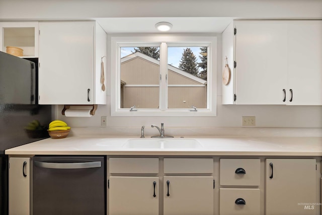 kitchen with light countertops, stainless steel dishwasher, a sink, and white cabinets