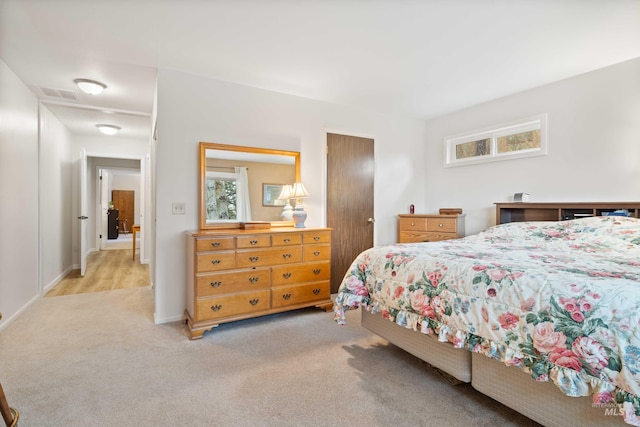 bedroom featuring light colored carpet, a closet, visible vents, and multiple windows