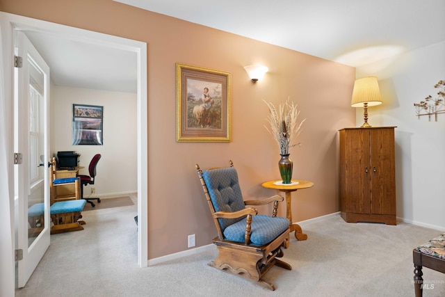 living area featuring carpet flooring and baseboards