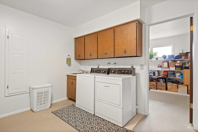 laundry area featuring light carpet, cabinet space, baseboards, separate washer and dryer, and a sink