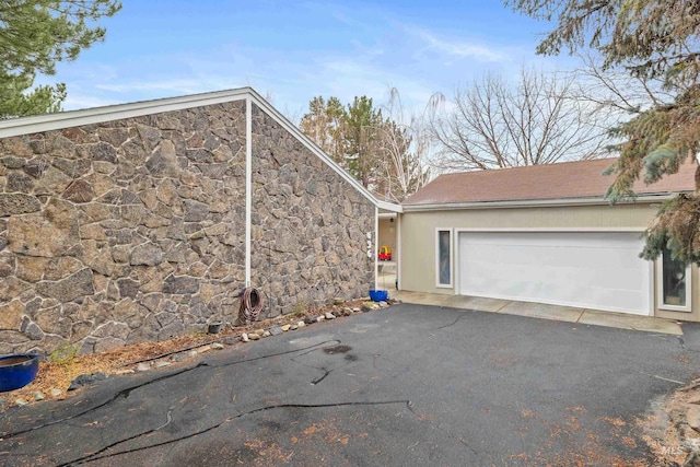 view of home's exterior featuring a garage and stone siding