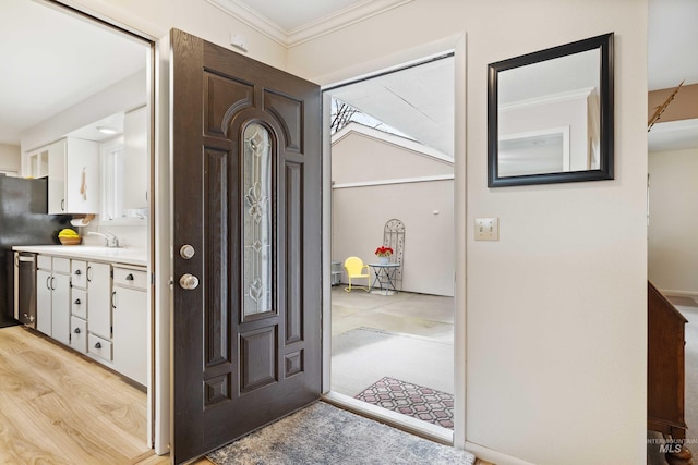 foyer featuring light wood-type flooring and crown molding