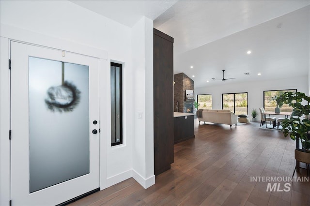 entryway with dark wood-style floors, recessed lighting, vaulted ceiling, and baseboards