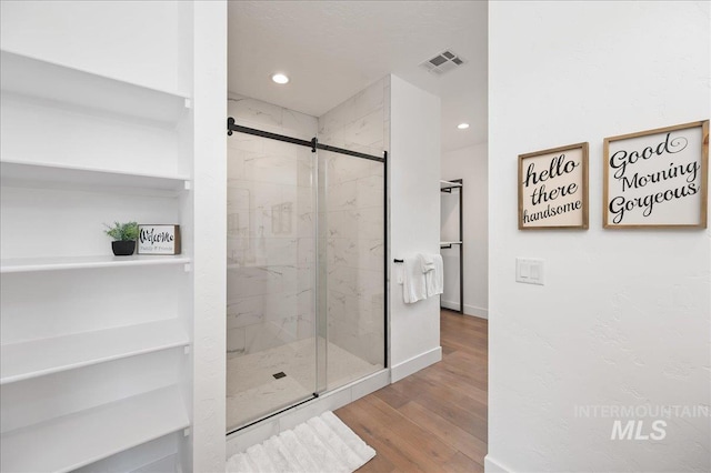 bathroom featuring recessed lighting, visible vents, a shower stall, and wood finished floors