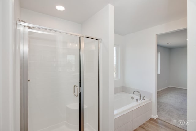 bathroom with plus walk in shower and wood-type flooring