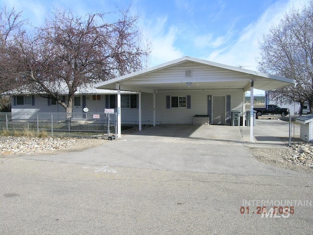 view of front of property featuring aphalt driveway, fence, and an attached carport