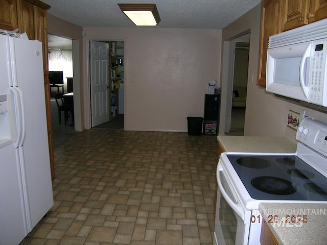 kitchen with white appliances and a textured ceiling