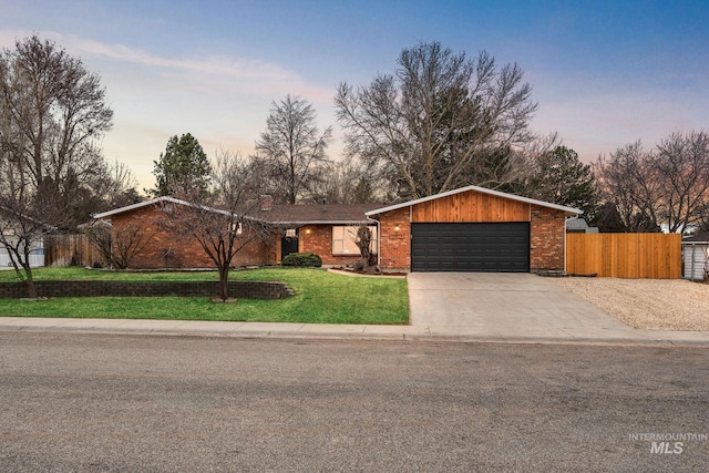 view of front of house with fence, driveway, a front lawn, a garage, and brick siding